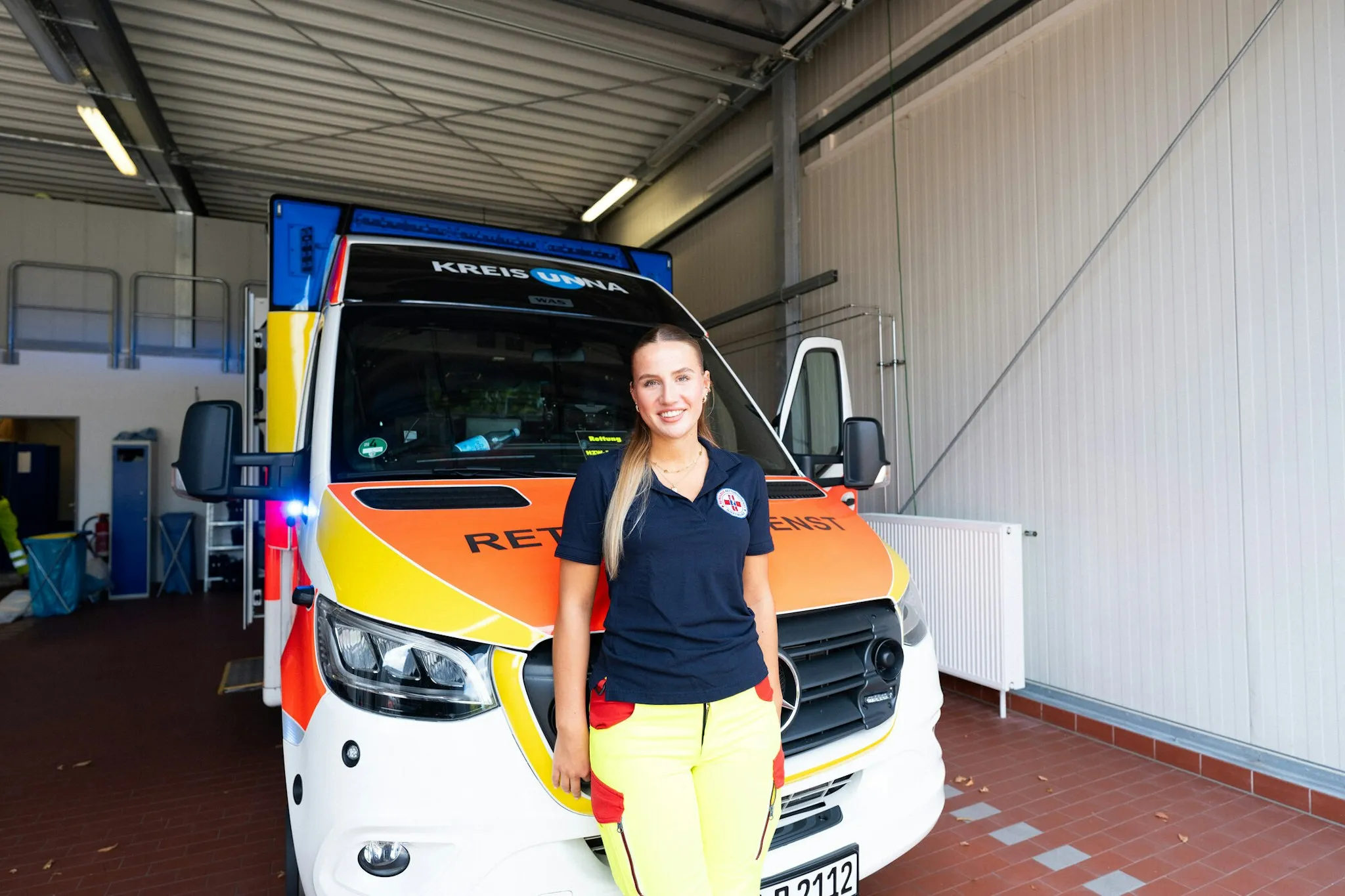 Woman standing in front of an ambulance.