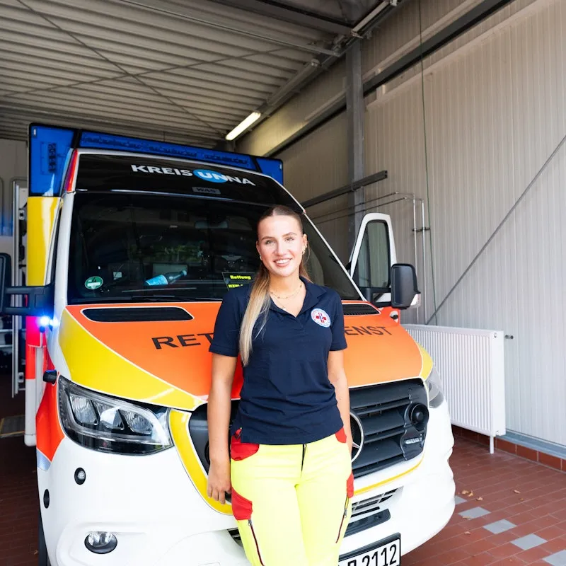 Woman standing in front of an ambulance.